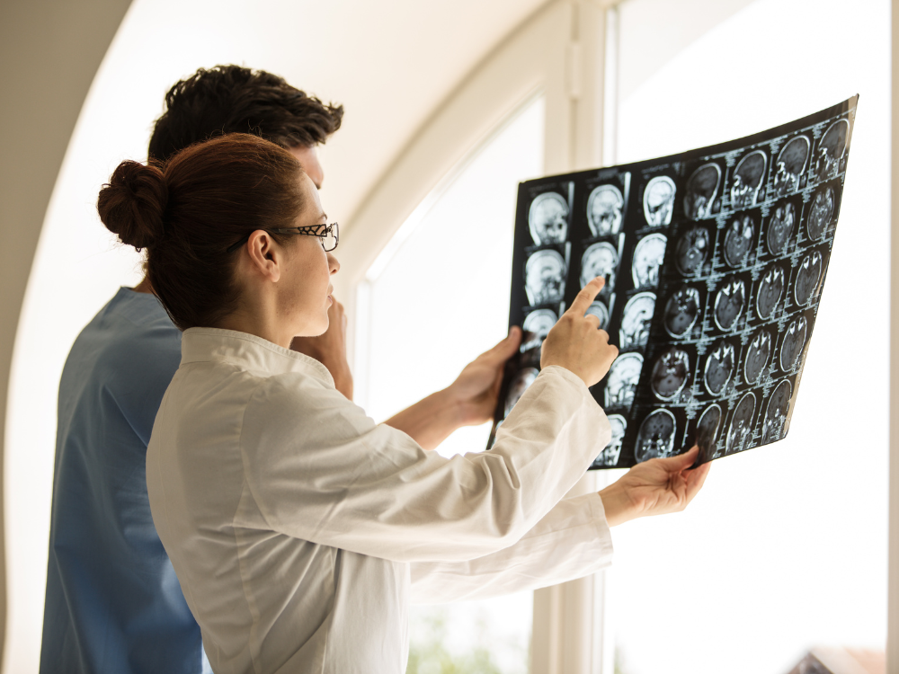 Neurosurgeons looking at x-rays of a brain tumor